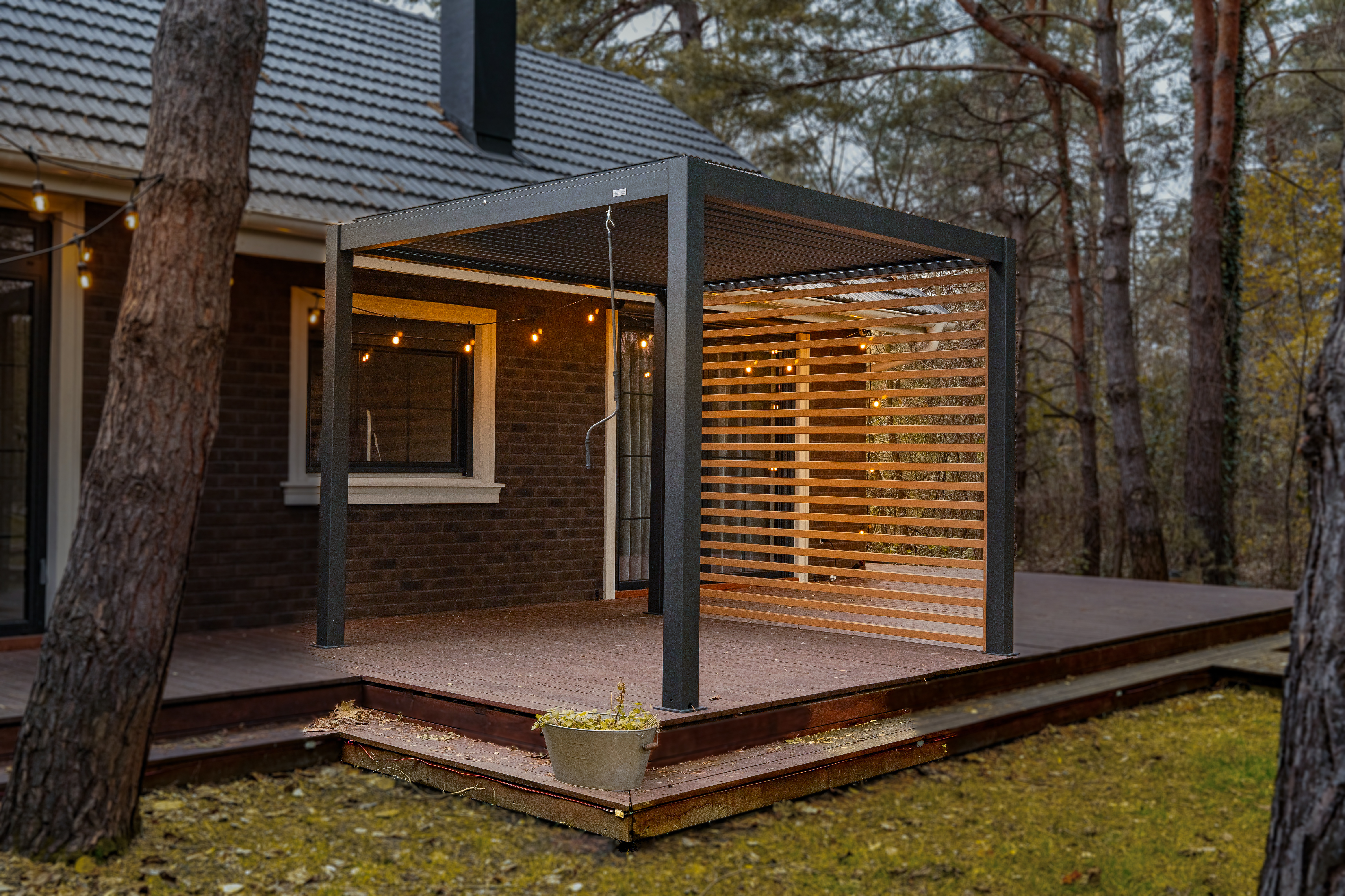 Hansø PRO+ aluminum pergola at dusk with louvered roof and integrated lighting